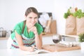 Young woman reading a recipe book in the kitchen Royalty Free Stock Photo