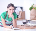 Young woman reading a recipe book in the kitchen Royalty Free Stock Photo