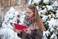 Young woman reading on a tablet in the winter on the street