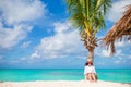 Young woman reading on tropical white beach near palm tree Royalty Free Stock Photo