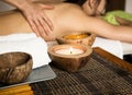 Young woman receiving a back massage in the spa salon. close-up of a candle and towels Royalty Free Stock Photo