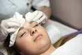 Young woman receiving beauty face therapy of cleaning pimple, ac