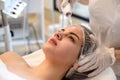 Young woman receiving electric darsonval facial massage treatment at beauty salon Royalty Free Stock Photo