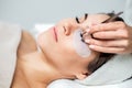 Woman receiving eyelash extension procedure