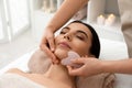 Young woman receiving massage with gua sha tool in beauty salon Royalty Free Stock Photo