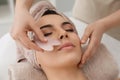 Young woman receiving facial massage with gua sha tool in beauty salon Royalty Free Stock Photo