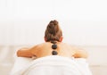 Young woman receiving hot stone massage. rear view Royalty Free Stock Photo