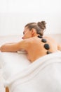 Young woman receiving hot stone massage. rear view Royalty Free Stock Photo