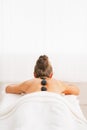 Young woman receiving hot stone massage. rear view Royalty Free Stock Photo