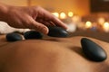 Using alternative therapy. A young woman receiving hot stone therapy at the spa. Royalty Free Stock Photo