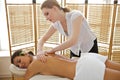 Young woman receiving massage from masseuse