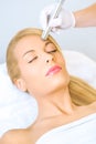 Young woman receiving microdermabrasion treatment