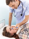 Young woman on reception at the doctor. Male ophthalmologist examining a patient's eyes.