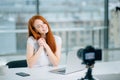 Young woman recording video on camera mounted on tripod for her vlog Royalty Free Stock Photo