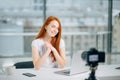 Young woman recording video on camera mounted on tripod for her vlog Royalty Free Stock Photo