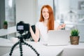 Young woman recording video on camera mounted on tripod for her vlog Royalty Free Stock Photo