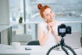 Young woman recording video on camera mounted on tripod for her vlog Royalty Free Stock Photo