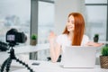 Young woman recording video on camera mounted on tripod for her vlog Royalty Free Stock Photo