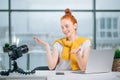 Young woman recording video on camera mounted on tripod for her vlog Royalty Free Stock Photo