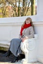 The young woman with red apple in a hand sits on a bench in the park Royalty Free Stock Photo