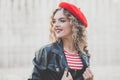 Young woman in red beret smiling, outdoor portrait