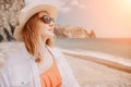 Young woman in red bikini on Beach. Blonde in sunglasses on pebble beach enjoying sun. Happy lady in one piece red Royalty Free Stock Photo