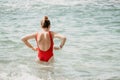 Young woman in red bikini on Beach. Happy lady in bathing suit chilling and sunbathing by turquoise sea ocean on hot Royalty Free Stock Photo