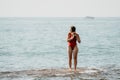 Young woman in red bikini on Beach. Happy lady in bathing suit chilling and sunbathing by turquoise sea ocean on hot Royalty Free Stock Photo