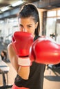 Young woman with red boxing gloves punching towards camera Royalty Free Stock Photo