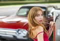 Young woman with red dress at the gas station. Attractive elegant girl refuel car on gas station. Royalty Free Stock Photo