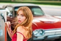 Young woman with red dress at the gas station. Attractive elegant girl refuel car on gas station. Royalty Free Stock Photo