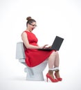 Young woman in red dress and glasses working on laptop sitting on toilet