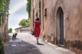 Young woman with red dress in the village of Joucas