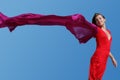 Young woman with red fluttering scarf on blue sky Royalty Free Stock Photo