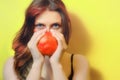 A young woman with a red garnet, copy space. Female portrait and red fruit. Girl with pomegranate on a yellow background Royalty Free Stock Photo