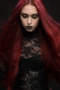 Young woman with red hair in black gothic costume Royalty Free Stock Photo
