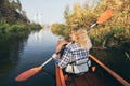 Young woman in red kayak rowing through the forest on the waters of Dnipro river in Kyiv, Ukraine