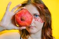 Young woman with red pomegranate. Girl with the garnet on a yellow background. Portrait of a woman and fruit Royalty Free Stock Photo