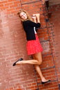 Young Woman Red Skirt, On Brick Wall LAdder Royalty Free Stock Photo