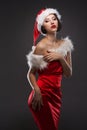 young woman in a red skirt and santa claus hat on a light background celebrates christmas Royalty Free Stock Photo