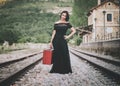 Young woman with a red suitcase on the train tracks Royalty Free Stock Photo