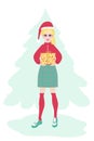 Young woman in a red sweater and a plaid skirt in a santa claus hat with a New Year\'s gift Royalty Free Stock Photo