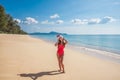 Young woman in red swimsuit and santa claus hat on the beach Royalty Free Stock Photo