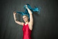 Young woman in red unitard waving a blue scarf. Royalty Free Stock Photo