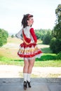 Young woman in red and white irish dance dress and wig posing