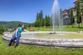 Young woman refreshing in the fountain in front of Cantacuzino castle in Busteni, Romania