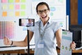 Young woman rejoicing and holding documents in front of mobile phone camera on tripod Royalty Free Stock Photo