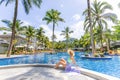 Young woman relaxes by the edge of a beautiful swimming pool Royalty Free Stock Photo