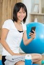 young woman relaxes with phone after yoga