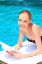 Young woman relaxing alongside a swimming pool